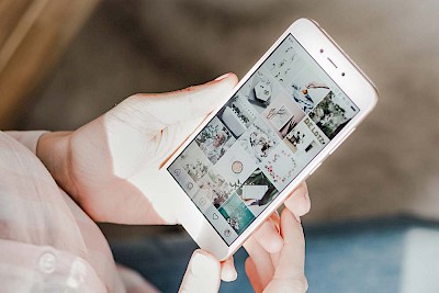 Smartphone mit Instagramfeed auf Bildschirm zur Veranschaulichung der Instagram Tools