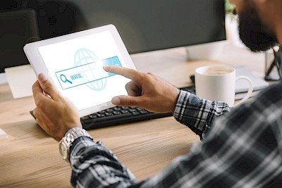 Mann an Tablet nutzt Web Suche