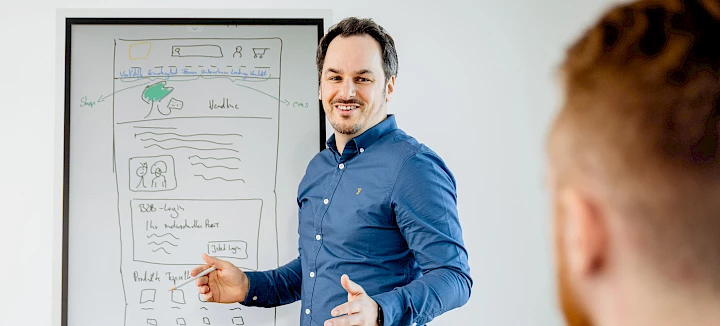 Timo Wormuth an einer Flip Chart zur Veranschaulichung der Leistungen