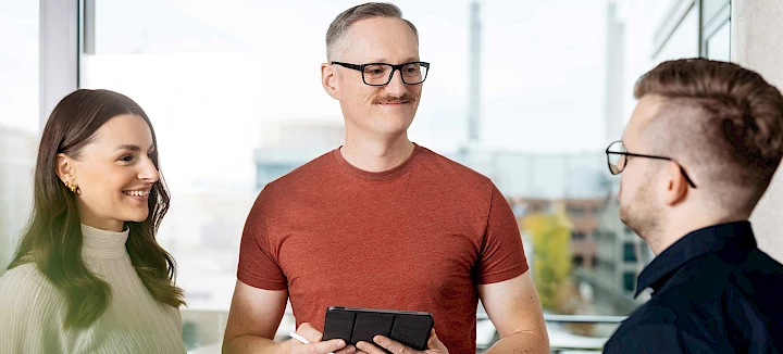 Drei Mitarbeitende des DREIKON Teams im Gespräch