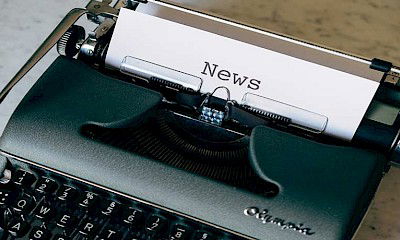 Picture of a typewriter printing paper with news