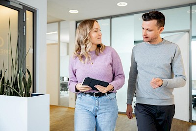 Woman with tablet and man talking about local marketing