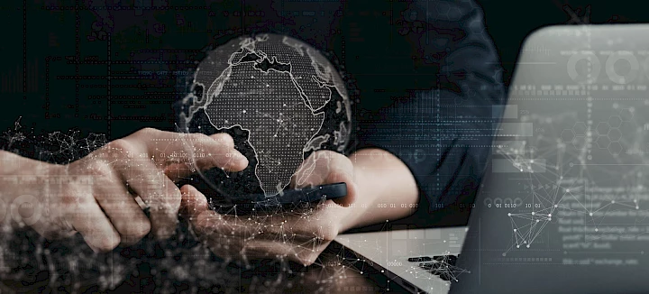 Weltkugel über Smartphone, Mensch an Laptop und Handy