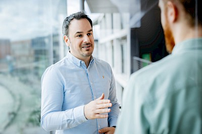 Man stands at the window and explains with a professional gesture