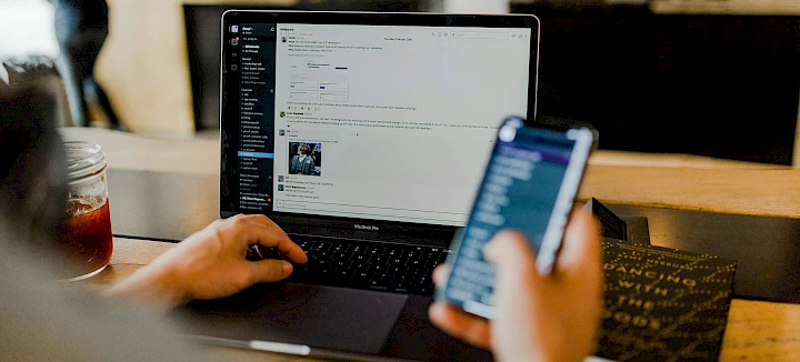 Persoon die telefoon en laptop gebruikt