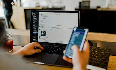 Person, die Telefon und Laptop benutzt