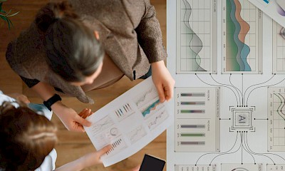 Zwei Mitarbeitende besprechen die Performance von KI