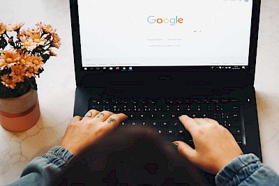 Frau von hinten vor dem laptop bei der Google-Suche