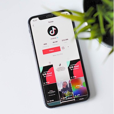 Smartphone mit Download der TikTok-App zur Veranschaulichung der Änderungen bei TikTok und Instagram